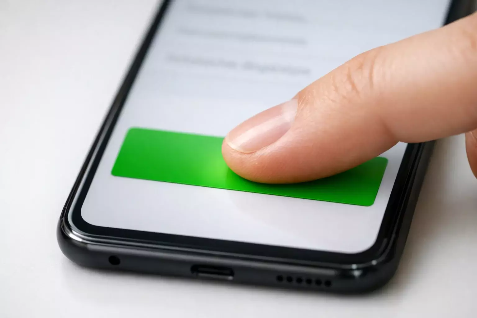 Hand tippt auf Smartphone-Bildschirm mit Bestätigungsgeste